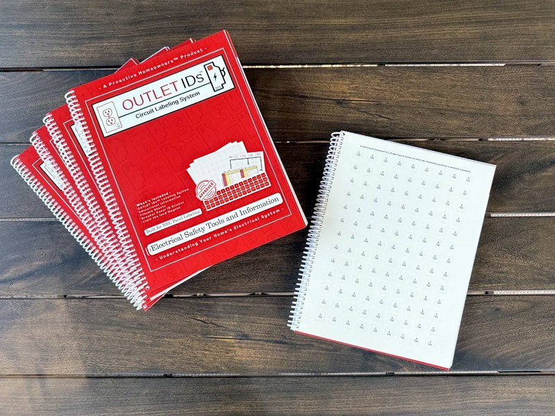 Fanned red OUTLET IDs books beside a page of numbered circuit labels